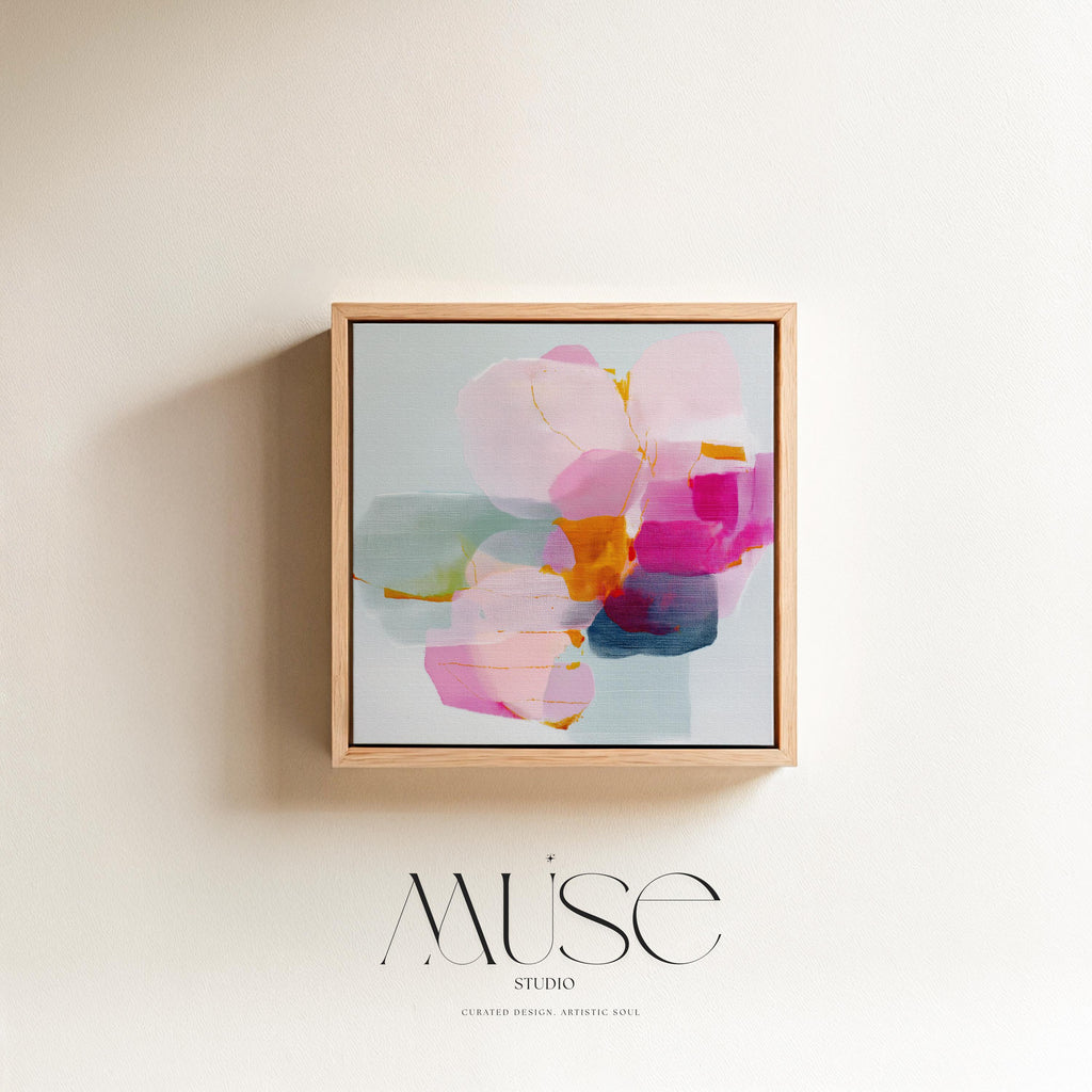 First Bloom 1052 by Muse Studio large framed floral wall art featuring blush pink, magenta, soft blue, and golden ochre painterly blooms printed with museum-grade giclée inks on premium gallery-wrapped canvas, framed in natural wood for Romantic Botanical bedrooms and serene designer interiors.