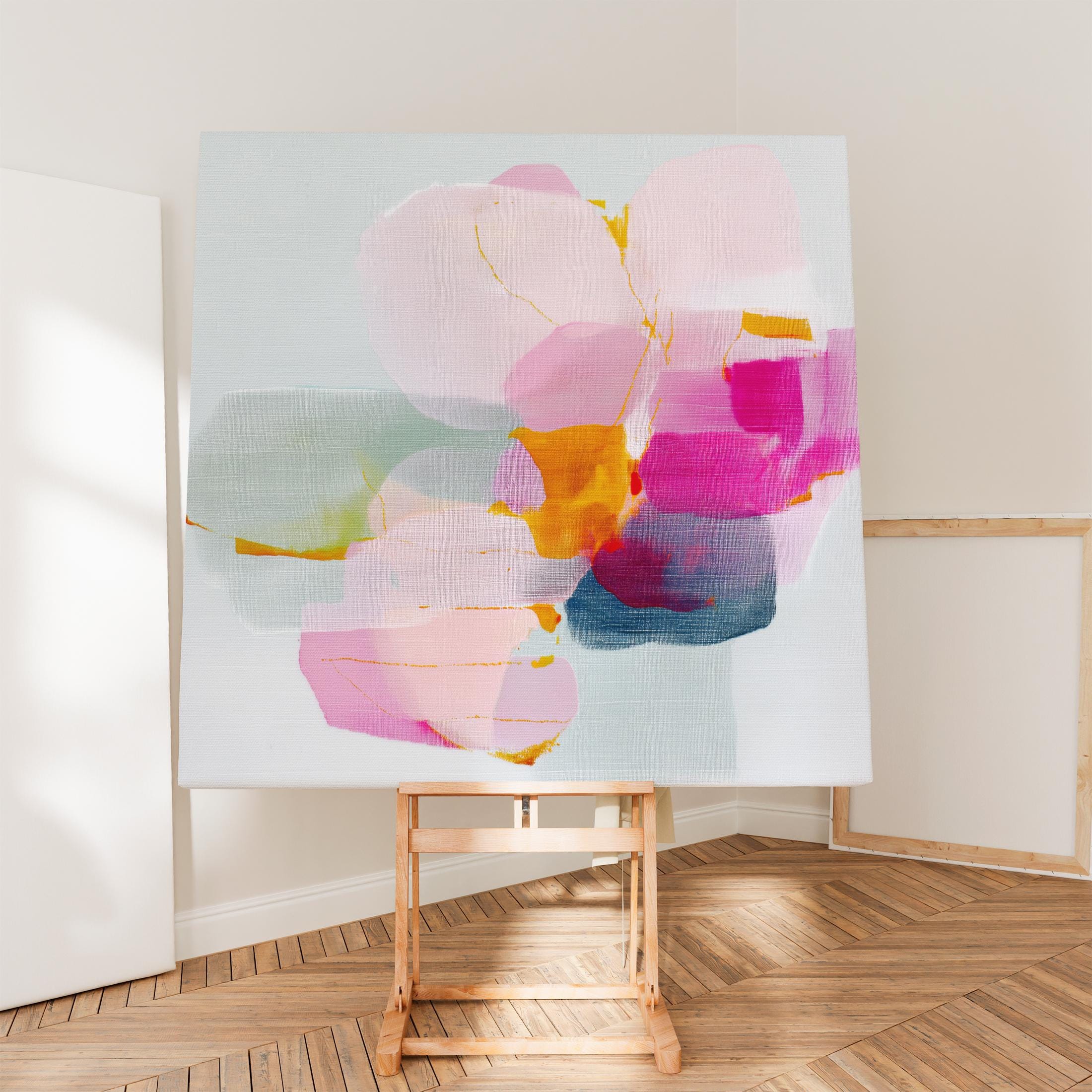 First Bloom 1052 by Muse Studio large square floral canvas wall art featuring blush pink, magenta, soft blue, and golden ochre abstract blooms printed with museum-grade giclée inks on premium gallery-wrapped artist canvas for Romantic Botanical bedrooms and bright contemporary interiors.