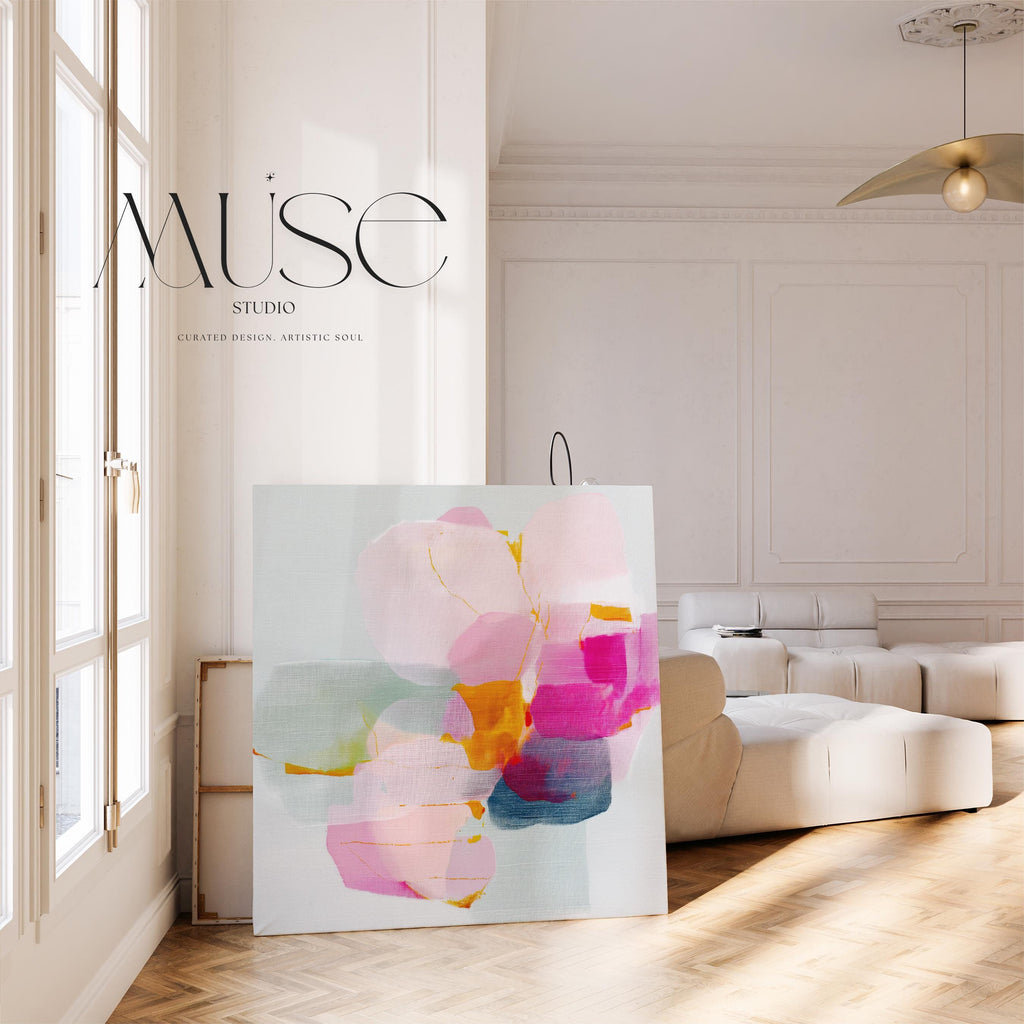 First Bloom 1052 by Muse Studio large square floral canvas wall art featuring blush pink, magenta, soft blue, and golden ochre abstract blooms printed with museum-grade giclée inks on premium gallery-wrapped artist canvas for Romantic Botanical bedrooms and bright contemporary interiors.