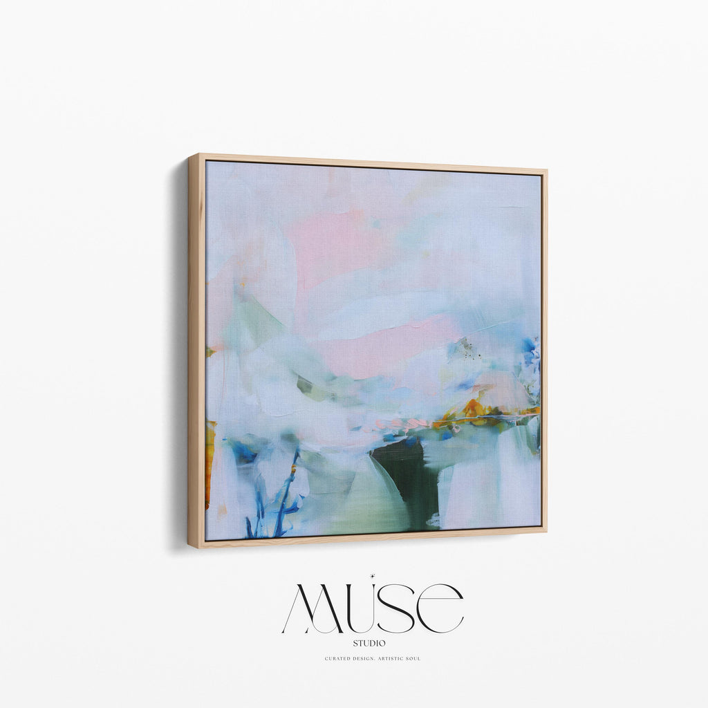 Muse Studio framed abstract wall art in soft blush, misted blue, pale sage, and deep teal with warm ochre accents, printed with museum-grade giclée inks on premium gallery-wrapped canvas, set in a natural wood float frame, styled above a neutral linen sofa in an organic transitional living room with warm oak tones and layered textures.