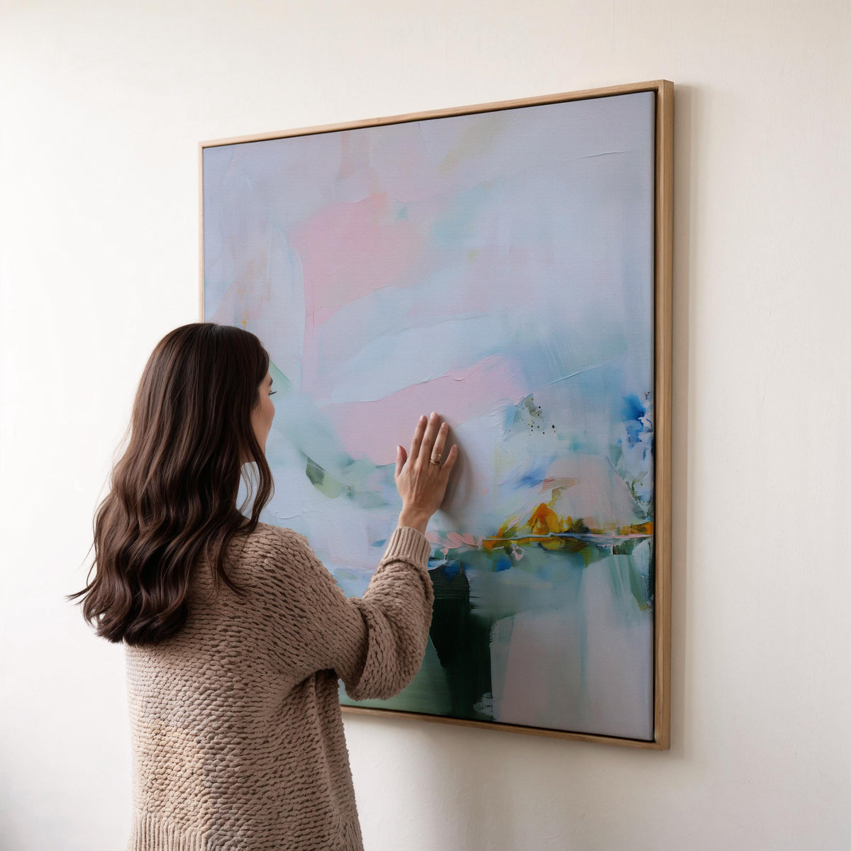 Muse Studio framed abstract wall art in soft blush, misted blue, pale sage, and deep teal with warm ochre accents, printed with museum-grade giclée inks on premium gallery-wrapped canvas, set in a natural wood float frame, styled above a neutral linen sofa in an organic transitional living room with warm oak tones and layered textures.