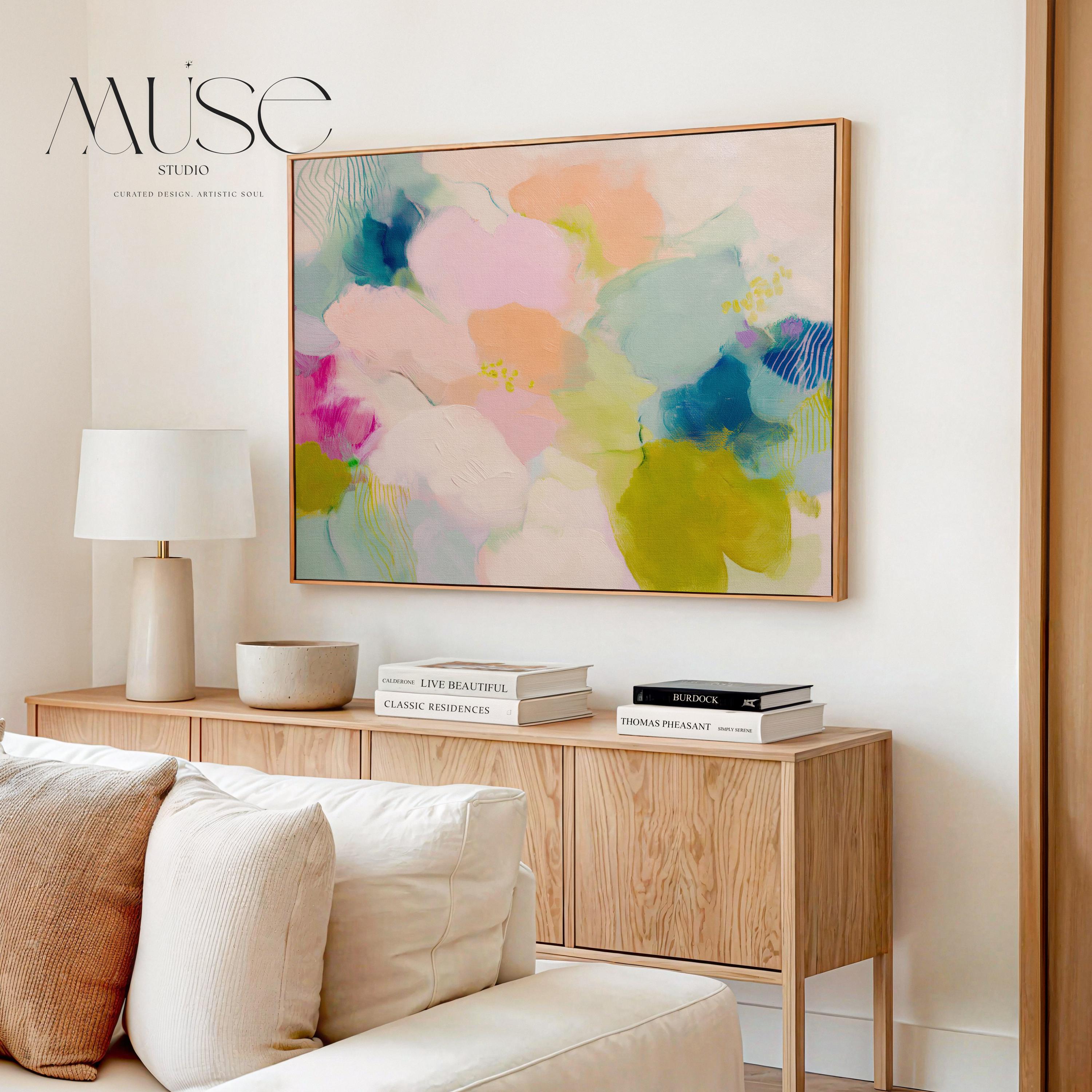 Muse Studio large framed abstract wall art on museum-grade artist canvas with fade-resistant giclée inks, framed in 100% solid wood with custom framing options in gold, silver, natural oak, black, and white, styled above a wood desk in a modern Soft Contemporary Pastel home office.