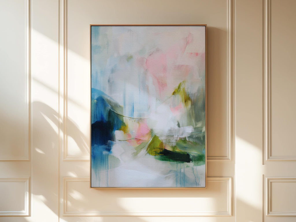 Spring Showers No. 1061 by Muse Studio & Co. vertical abstract wall art in blue, blush pink, and green tones, printed with museum-grade giclée inks on premium gallery-wrapped canvas and framed in natural wood float frame, styled in a serene bedroom above bed in soft contemporary interior.