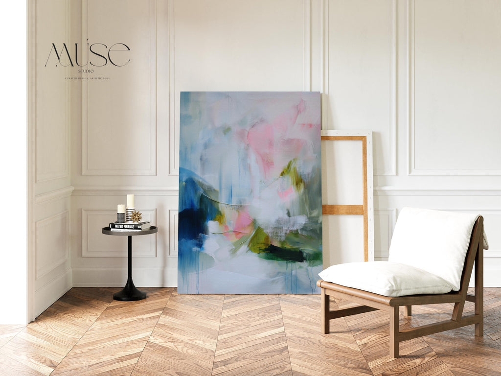 Spring Showers No. 1061 by Muse Studio & Co. vertical abstract canvas wall art in blue, blush pink, and soft green tones with a cottage botanical style, printed with museum-grade giclée inks on premium gallery-wrapped canvas, styled above a linen bed in a romantic cottage bedroom with soft contemporary decor.