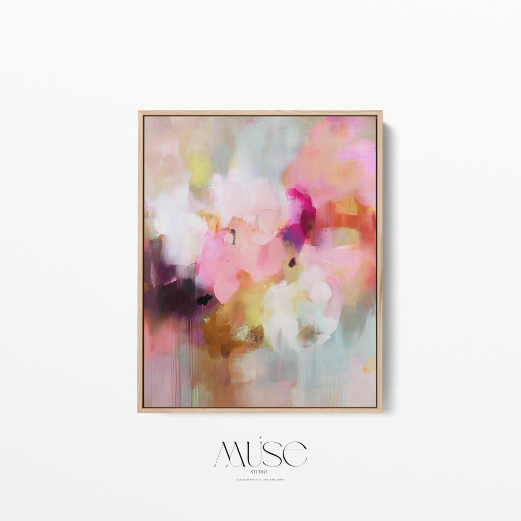 Spring Showers No. 1061 by Muse Studio & Co. vertical framed abstract wall art in blush pink, coral, ochre, and soft aqua tones, printed with museum-grade giclée inks on premium canvas and finished in a natural wood float frame, styled in a boho living room with warm neutral textures and layered decor.