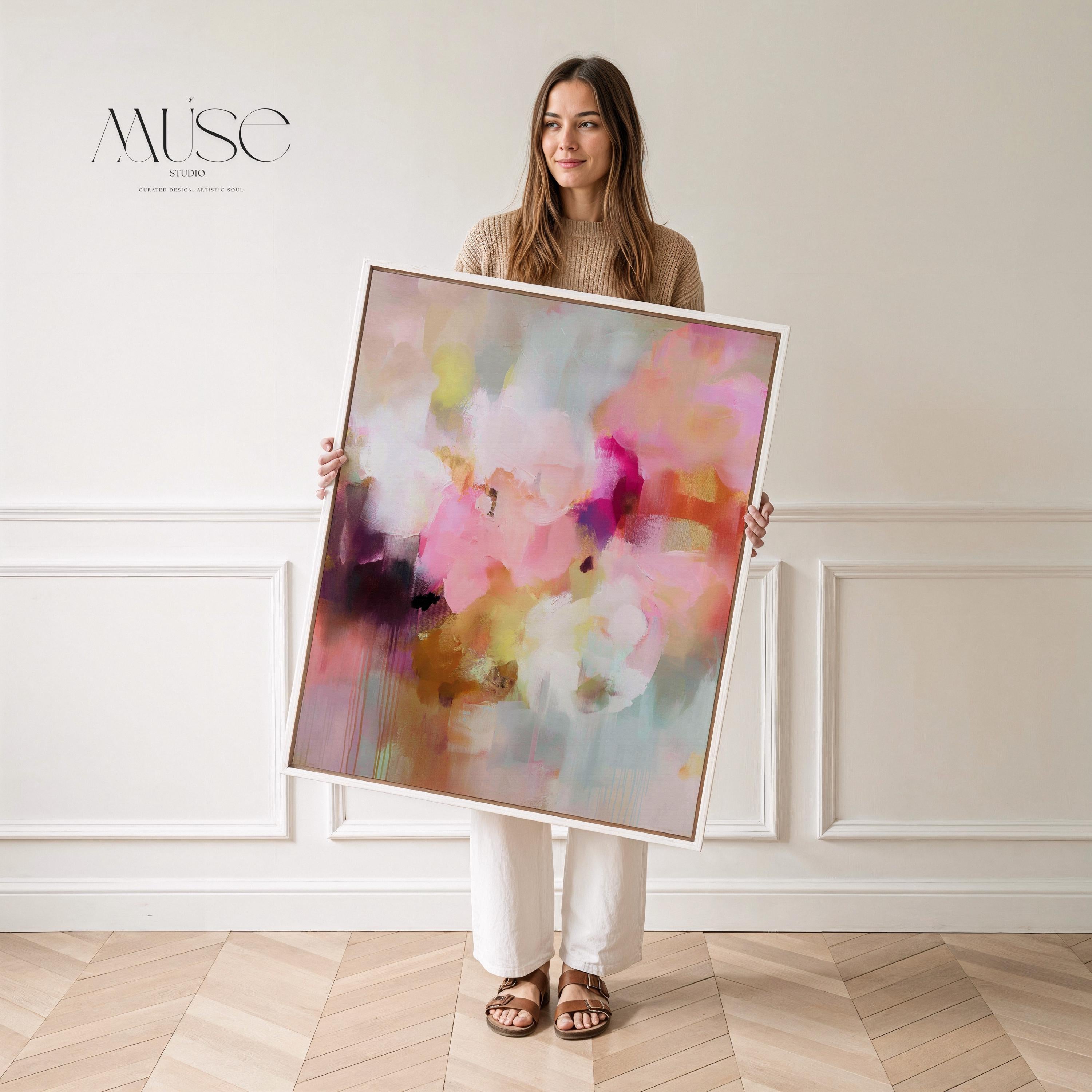 Spring Showers No. 1061 by Muse Studio & Co. vertical framed abstract wall art in blush pink, coral, ochre, and soft aqua tones, printed with museum-grade giclée inks on premium canvas and finished in a natural wood float frame, styled in a boho living room with warm neutral textures and layered decor.