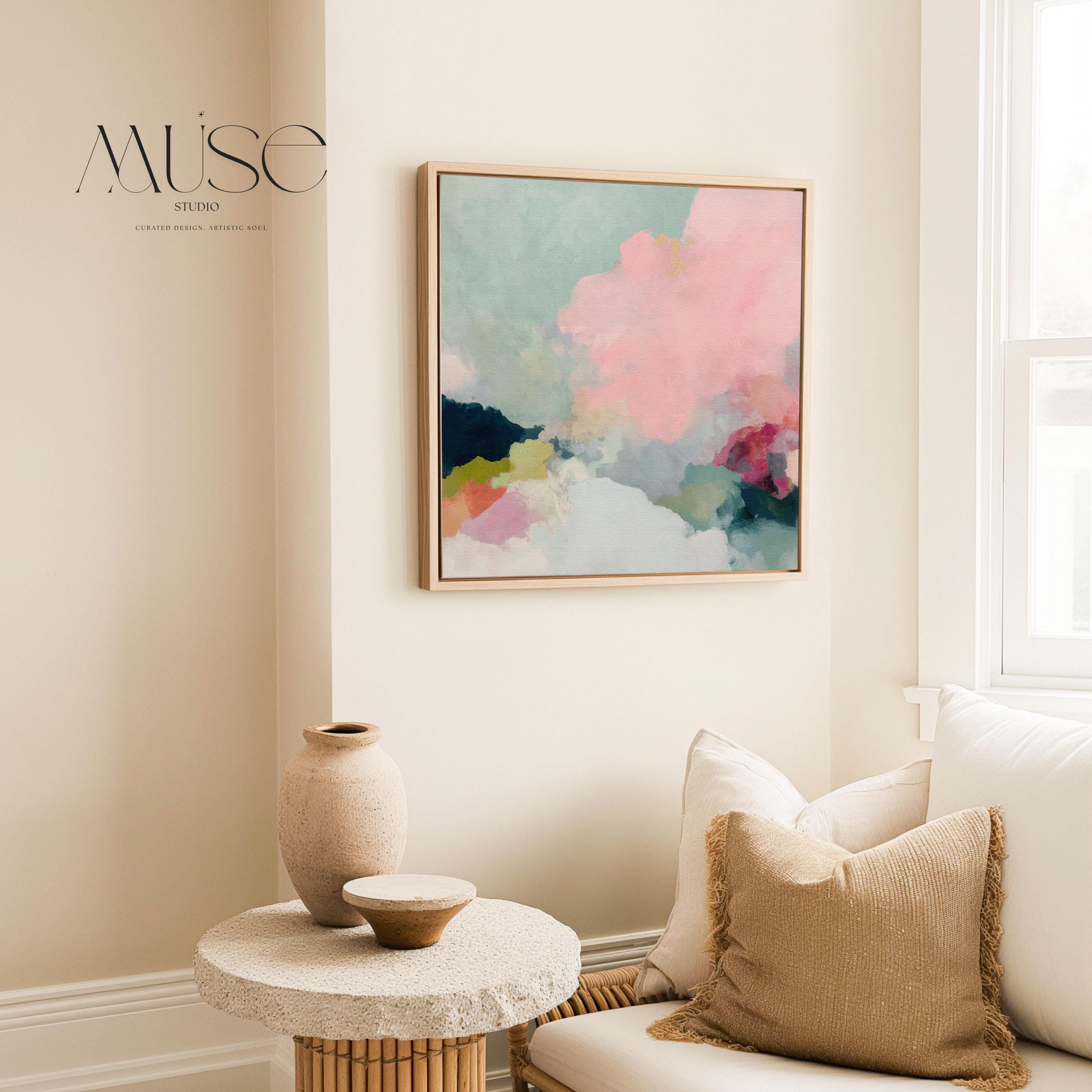 Square framed pastel abstract wall art by Muse Studio featuring blush pink cloud-like forms with soft green and cream tones. Printed with museum-grade giclée inks on premium artist canvas and finished in custom wood float frames in natural, white, black, or antique gold and silver, designed for bedrooms or serene living spaces.
