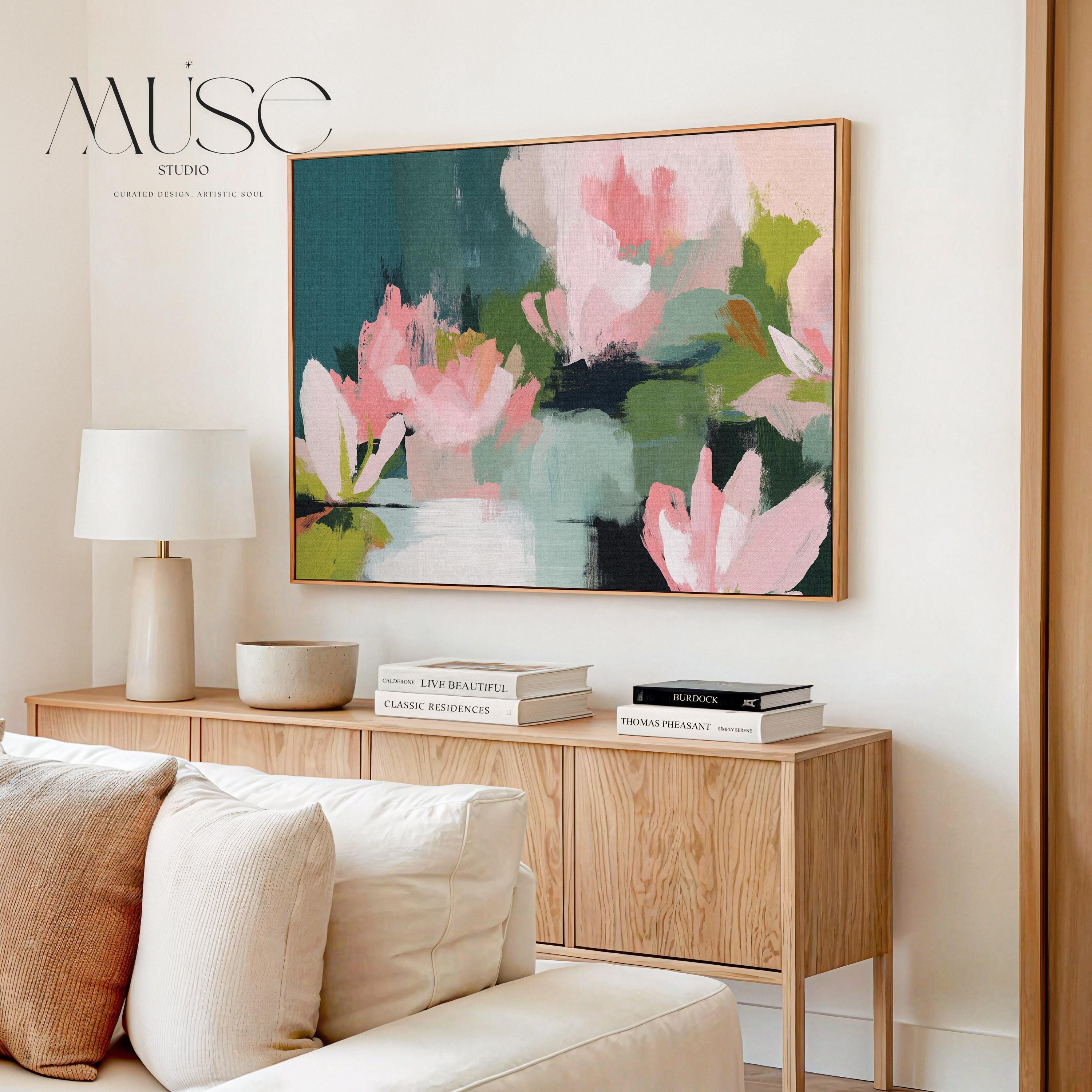 Magnolia Reverie No. 1037 by Muse Studio & Co. blush pink magnolia floral wall art with sage green and deep teal botanical brushwork printed with museum-grade giclée inks on premium gallery-wrapped cotton canvas and custom framed in natural wood with optional white, black, antique gold, or antique silver float frames to complement any decor style, styled in a coastal tropical beach home living room with airy interiors and light wood floors.