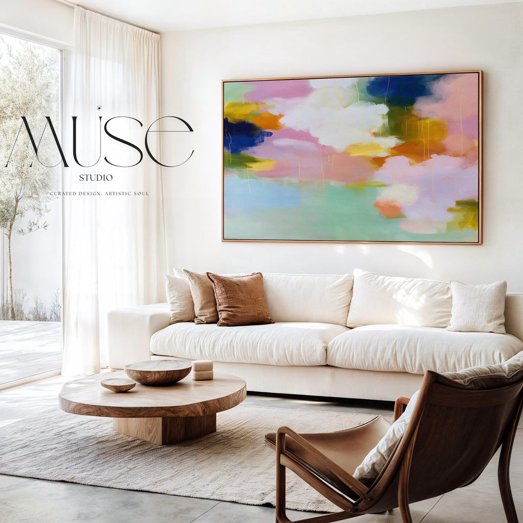 Blush Crescendo No. 291 by Muse Studio & Co. large horizontal pastel abstract framed canvas wall art in blush pink, teal and cream tones printed with museum-grade giclée inks on premium gallery-wrapped artist canvas with custom float frame options in natural, white, black, antique gold or antique silver, styled above a sofa in a soft contemporary living room.