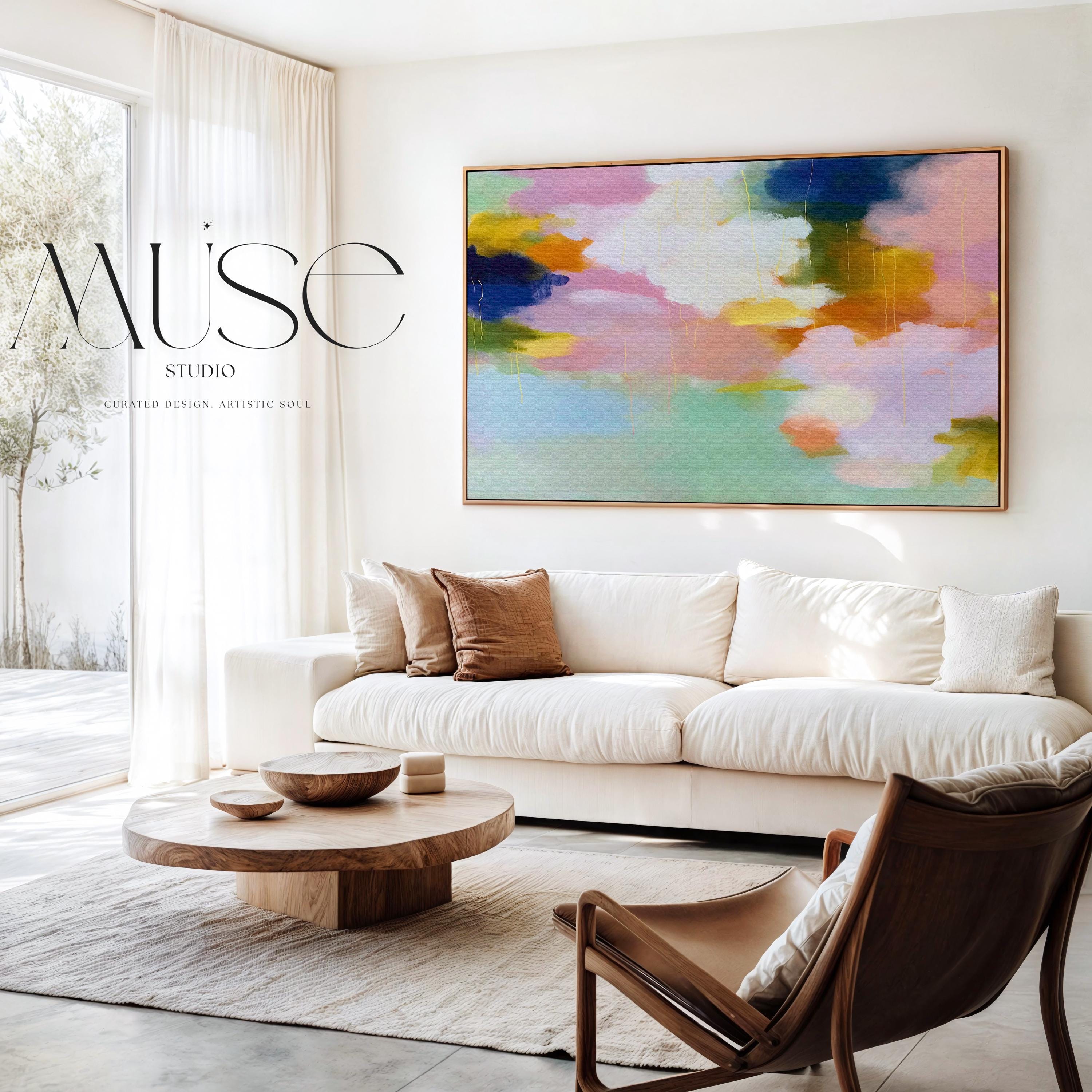 Blush Crescendo No. 291 by Muse Studio & Co. large horizontal pastel abstract framed canvas wall art in blush pink, teal and cream tones printed with museum-grade giclée inks on premium gallery-wrapped artist canvas with custom float frame options in natural, white, black, antique gold or antique silver, styled above a sofa in a soft contemporary living room.