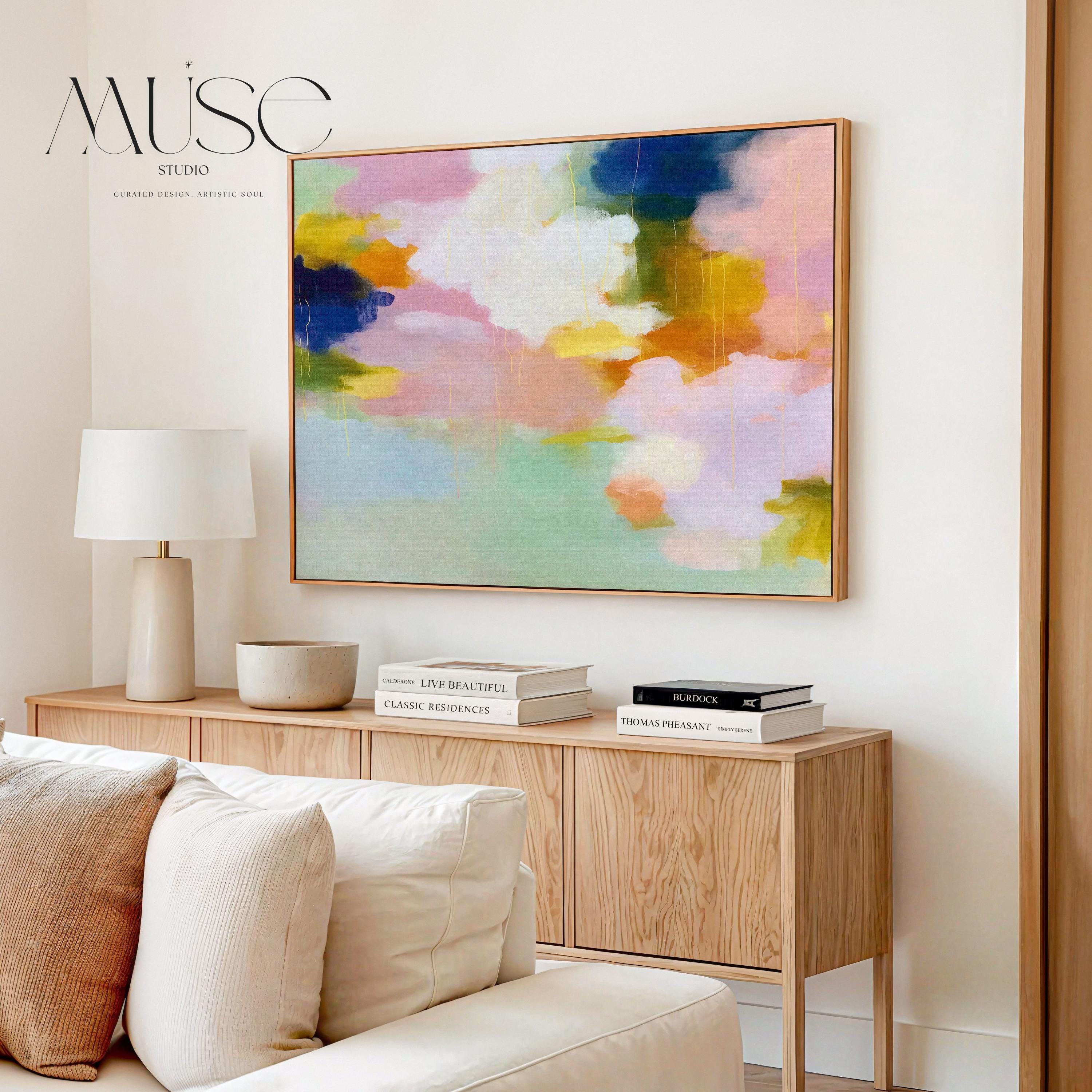 Blush Crescendo No. 291 by Muse Studio & Co. large horizontal pastel abstract framed canvas wall art in blush pink, teal and cream tones printed with museum-grade giclée inks on premium gallery-wrapped artist canvas with custom float frame options in natural, white, black, antique gold or antique silver, styled above a sofa in a soft contemporary living room.