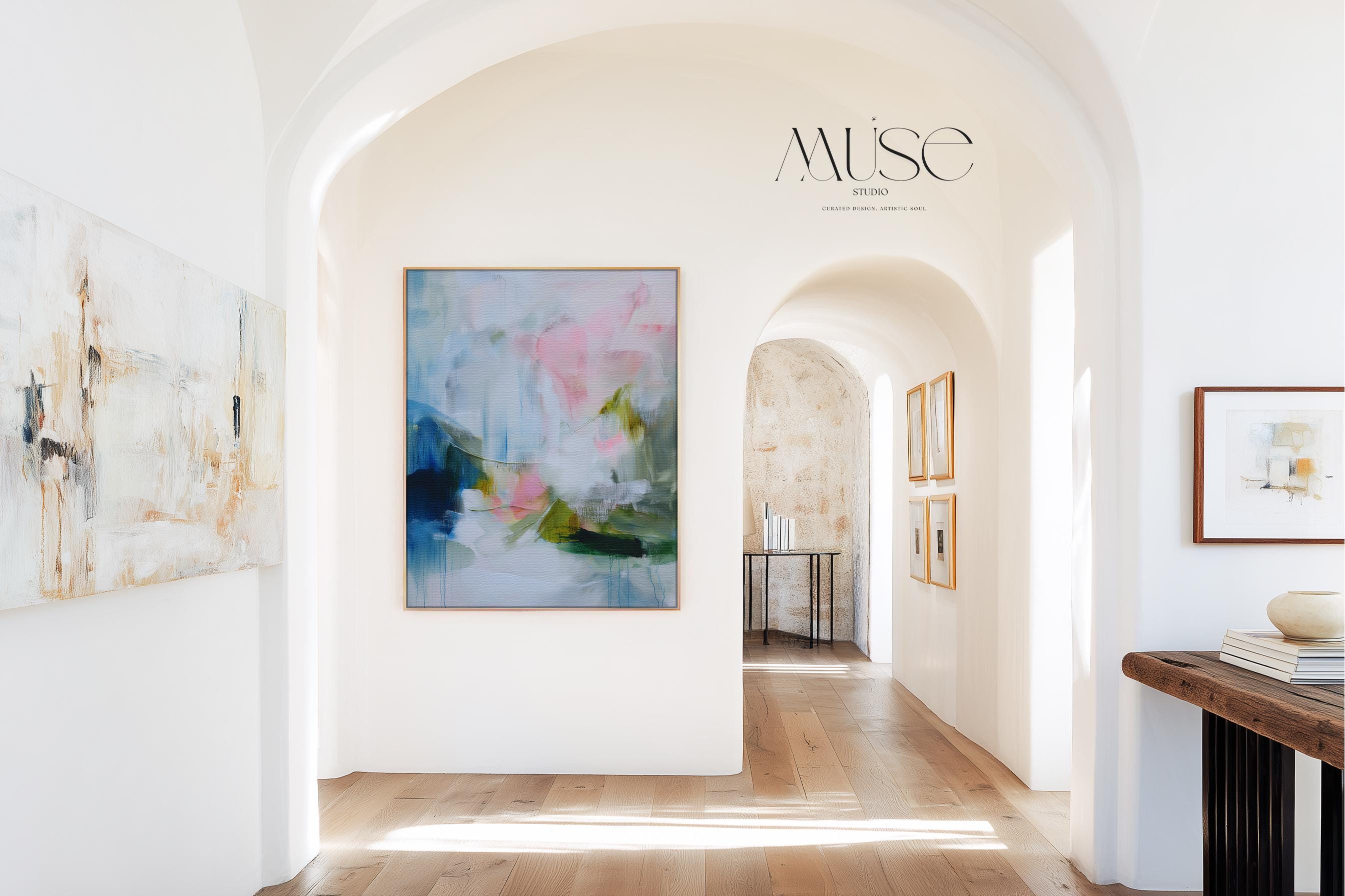 Spring Showers No. 1061 by Muse Studio & Co. vertical abstract wall art in blue, blush pink, and green tones, printed with museum-grade giclée inks on premium gallery-wrapped canvas and framed in natural wood float frame, styled in a serene bedroom above bed in soft contemporary interior.