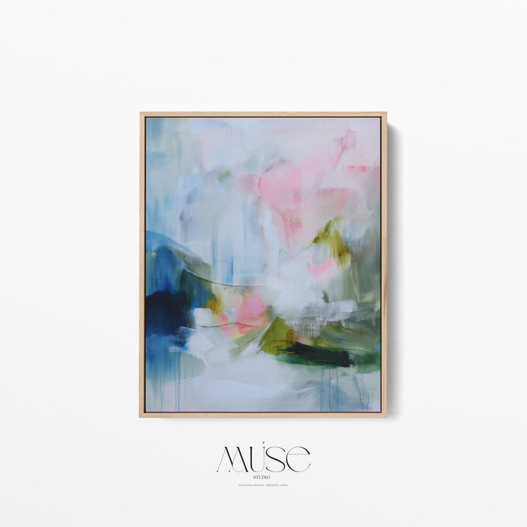 Spring Showers No. 1061 by Muse Studio & Co. vertical abstract wall art in blue, blush pink, and green tones, printed with museum-grade giclée inks on premium gallery-wrapped canvas and framed in natural wood float frame, styled in a serene bedroom above bed in soft contemporary interior.