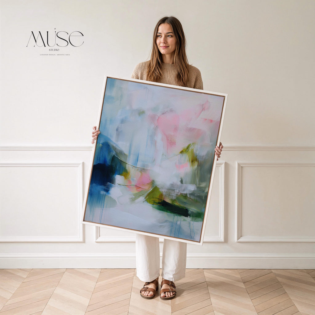 Spring Showers No. 1061 by Muse Studio & Co. vertical abstract wall art in blue, blush pink, and green tones, printed with museum-grade giclée inks on premium gallery-wrapped canvas and framed in natural wood float frame, styled in a serene bedroom above bed in soft contemporary interior.