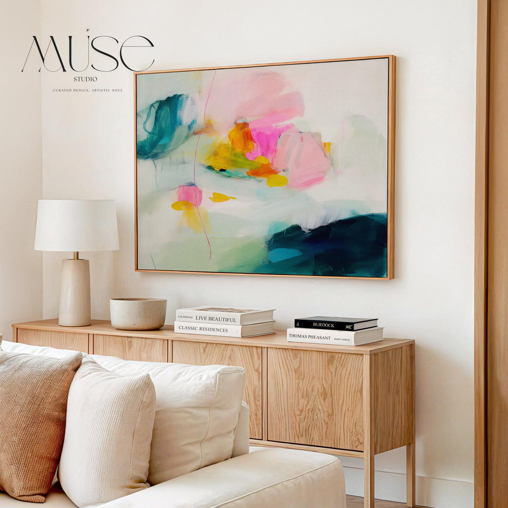 Poppy Fields No. 454 by Muse Studio & Co. horizontal colorful abstract wall art in pink, teal, yellow, and cream printed with museum-grade giclée inks on premium canvas, custom framed in natural, white, black, antique gold or silver float frame, styled in a bright designer living room.