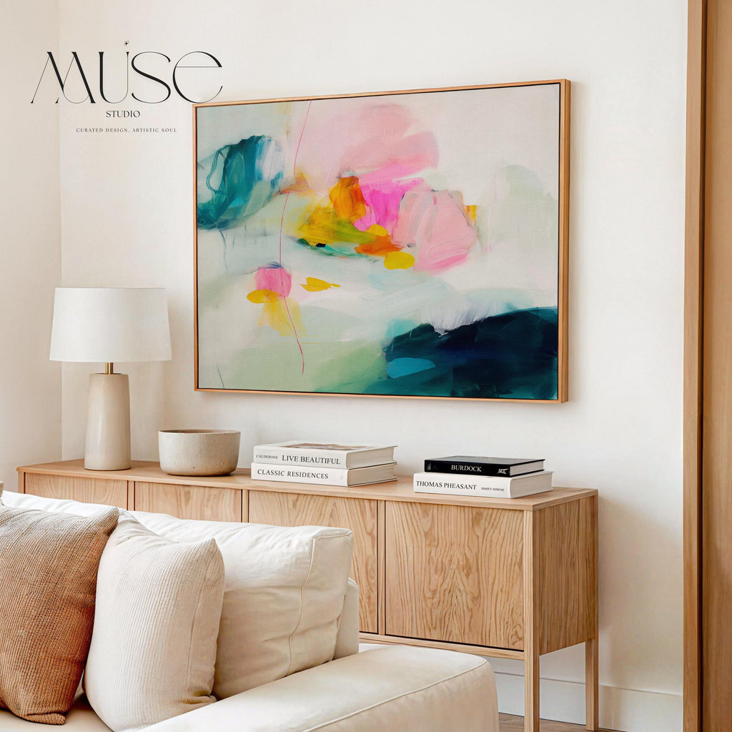 Poppy Fields No. 454 by Muse Studio & Co. horizontal colorful abstract wall art in pink, teal, yellow, and cream printed with museum-grade giclée inks on premium canvas, custom framed in natural, white, black, antique gold or silver float frame, styled in a bright designer living room.