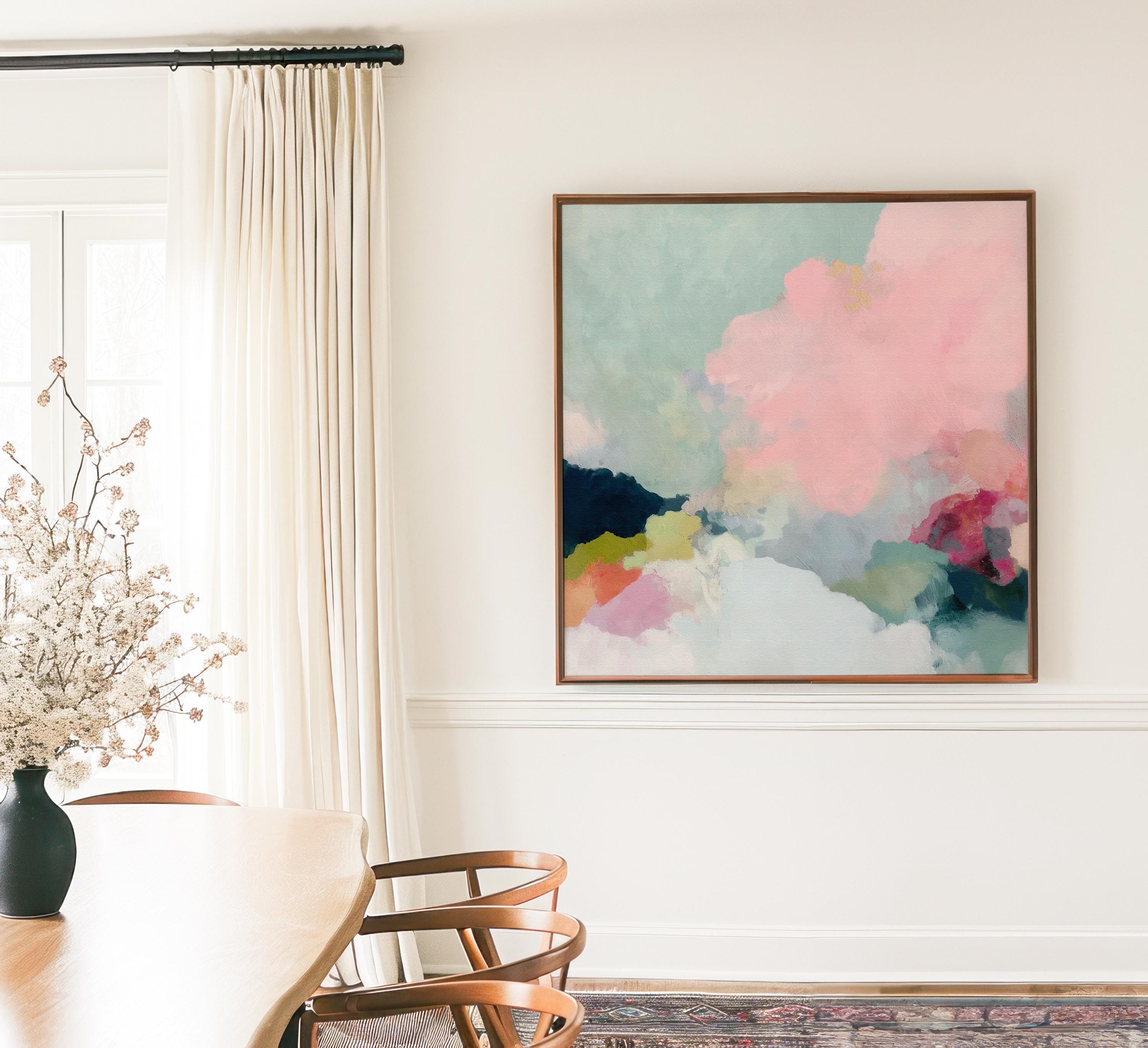 Square framed pastel abstract wall art by Muse Studio featuring blush pink cloud-like forms with soft green and cream tones. Printed with museum-grade giclée inks on premium artist canvas and finished in custom wood float frames in natural, white, black, or antique gold and silver, designed for bedrooms or serene living spaces.