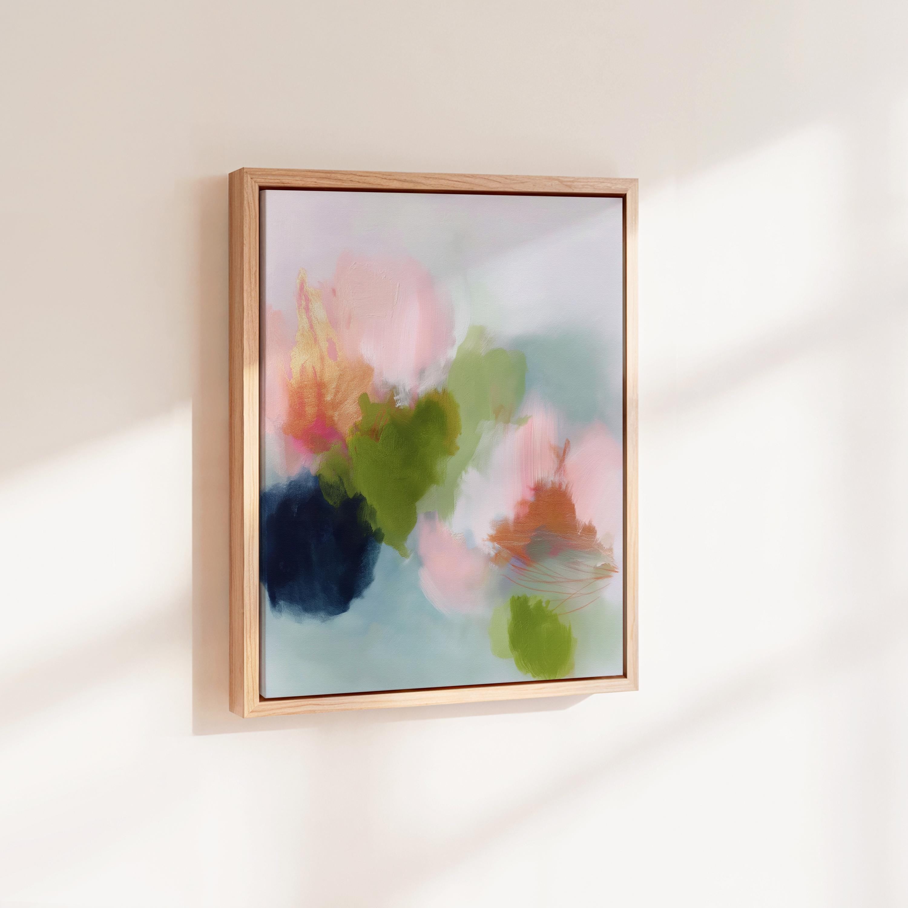 Muse Studio framed wall art in blush pink, olive green, soft aqua, and peach floral abstract tones, printed with museum-grade giclée inks on premium artist canvas and available in custom natural, white, black, antique gold, or antique silver float frames, styled as vertical statement artwork for a bedroom, office, or living room.