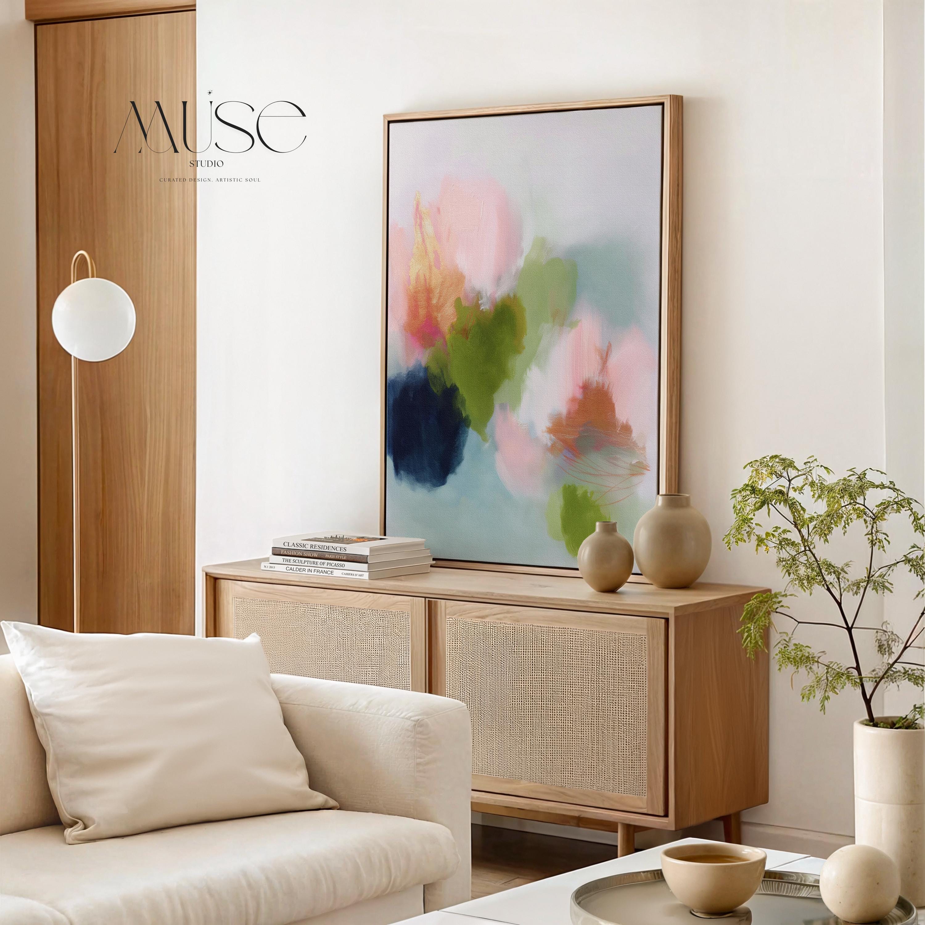 Muse Studio framed wall art in blush pink, olive green, soft aqua, and peach floral abstract tones, printed with museum-grade giclée inks on premium artist canvas and available in custom natural, white, black, antique gold, or antique silver float frames, styled as vertical statement artwork for a bedroom, office, or living room.