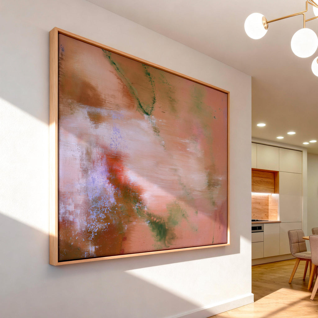 Large framed warm abstract wall art in light wood frame mounted in a modern sunlit dining room with soft interior lighting.